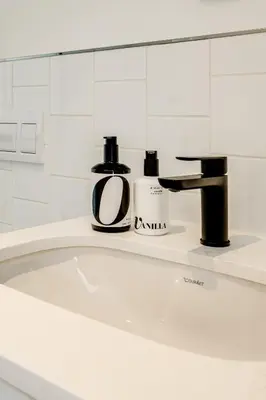 a bathroom with a bath tub with a sink at Belina - Nine Palms Premier in Cape Town