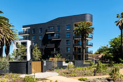 a building with a palm tree in front of it at Belina - Nine Palms Premier in Cape Town