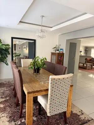 a dining room with a wooden table and chairs at Entertainers delight near the beach & wine routes in Cape Town