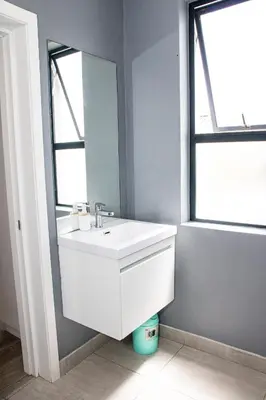 a bathroom with a white sink and a mirror at B&B Sitari County Estate - The Most Iconic Estate in Cape Town