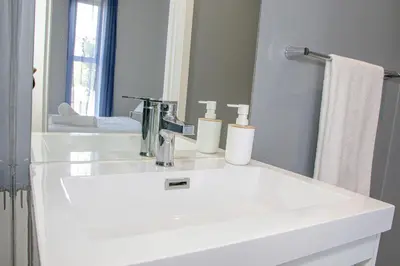 a bathroom with a white sink and a mirror at B&B Sitari County Estate - The Most Iconic Estate in Cape Town