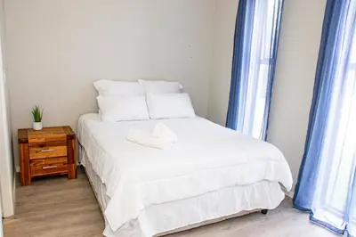 a bedroom with a bed with a stuffed animal on it at B&B Sitari County Estate - The Most Iconic Estate in Cape Town
