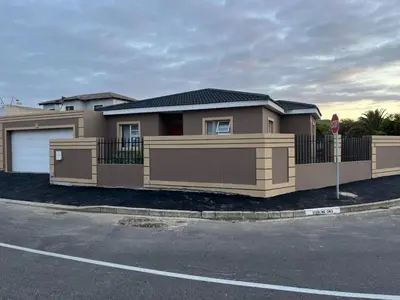 a brown house with a gate and a stop sign at West Coast comfortable stays in Cape Town