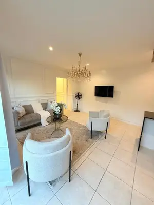 a living room with a couch and chairs and a tv at DOMIN LUXURY SUITES in Cape Town