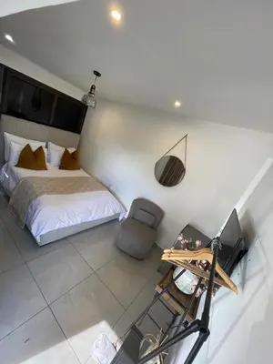 a bedroom with a bed and a chair and a desk at DOMIN LUXURY SUITES in Cape Town
