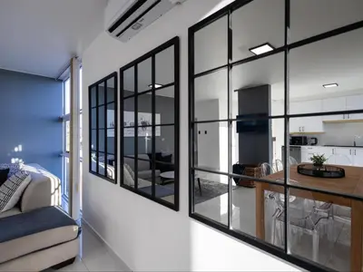 a living room with large windows and a table at St Tropez Beachfront 101 in Strand