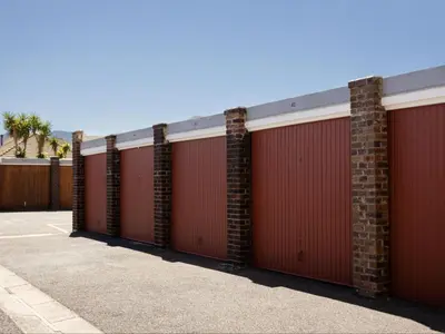 a row of red garage doors on a building at St Tropez Beachfront 101 in Strand
