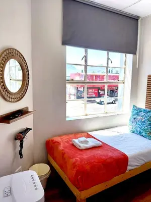a bedroom with a bed with a red blanket and a window at The Stetson - Paarl - Self Catering Apartment in Paarl