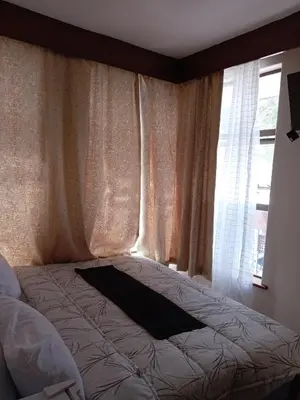 a bed sitting in a bedroom with a window at 37 Toner Street North in Cape Town