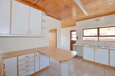 a kitchen with white cabinets and a wooden ceiling at 37 Toner Street North in Cape Town