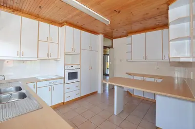 a kitchen with white cabinets and a wooden ceiling at 37 Toner Street North in Cape Town