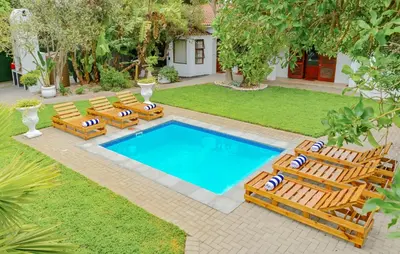 an image of a swimming pool with lounge chairs at Spray Villa Bloubergstrand with hot tub and close to the beach in Bloubergstrand