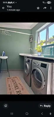 a kitchen with a washing machine in a room at Spray Villa Bloubergstrand with hot tub and close to the beach in Bloubergstrand