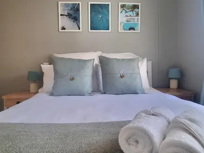 a bedroom with a bed with white sheets and pillows at Ocean Escape in Strand