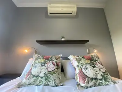 a bedroom with a bed with two pillows on it at Studio 23 @ Huis Piron. The Heart of Stellenbosch. in Stellenbosch