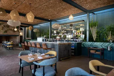 a restaurant with tables and chairs and a bar at Laborie Jonkershuis in Paarl