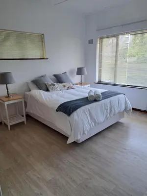 a bedroom with a bed and two lamps and a window at A cosy home in Hermanus in Hermanus