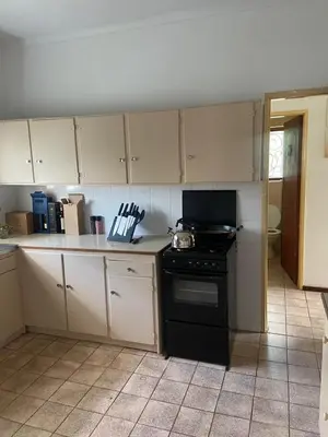 a kitchen with a black stove and white cabinets at A cosy home in Hermanus in Hermanus