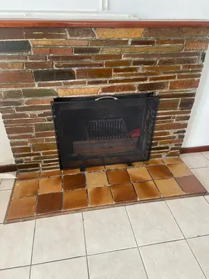 a fireplace with a brick wall at A cosy home in Hermanus in Hermanus