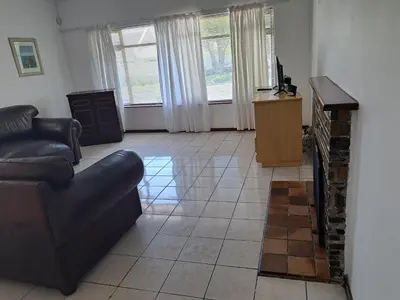 a living room with a couch and a fireplace at A cosy home in Hermanus in Hermanus