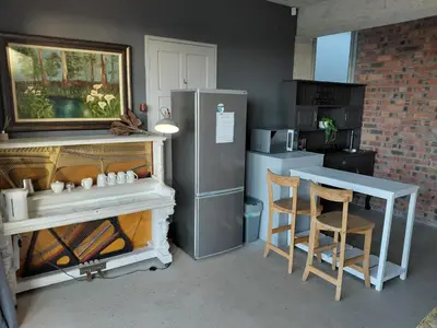 a kitchen with a refrigerator and a table and chairs at Chapman View Studio in Cape Town