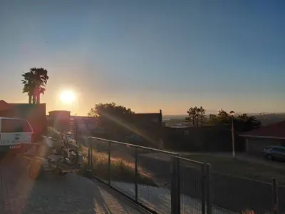 a truck parked next to a fence at sunset at Chapman View Studio in Cape Town
