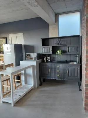 a kitchen with a black cabinet and a white table at Chapman View Studio in Cape Town