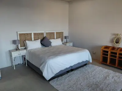 a bedroom with a large bed with a nightstand and a bed sidx sidx sidx at Chapman View Studio in Cape Town