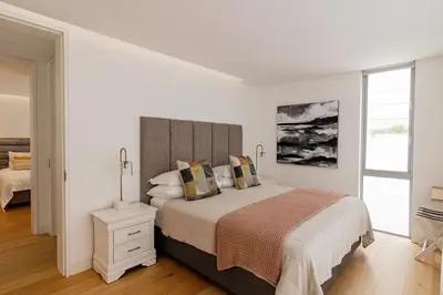 a white bedroom with a large bed and a window at 91 Atlantic Drive in Hermanus
