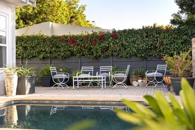 a patio with chairs and a table next to a fence at 55 MainStay in Hermanus