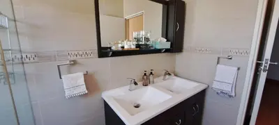 a bathroom with a sink and a mirror at Blouberg Beach Villa in Cape Town