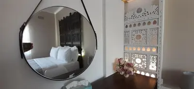 a mirror in a room with a bed and a bedroom at Blouberg Beach Villa in Cape Town