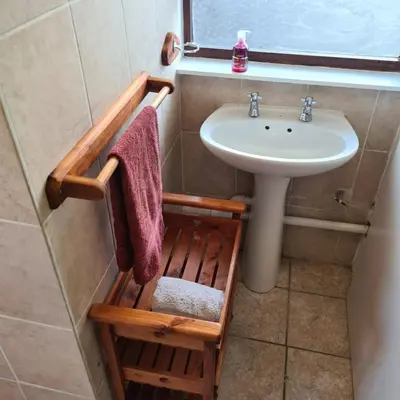 a bathroom with a sink and a towel rack next to a sink at Mads Place in Cape Town