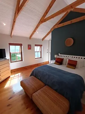 a bedroom with a large bed and a couch at d'Vine Maison in Franschhoek