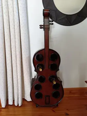 a violin leaning against a wall next to a curtain at d'Vine Maison in Franschhoek
