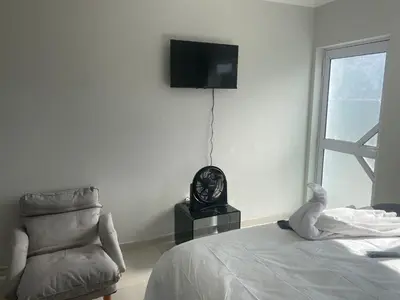 a bedroom with a bed and a clock and a chair at 5 AntiP in Cape Town