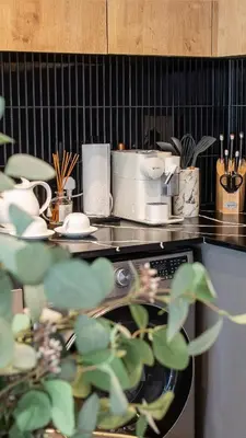 a kitchen with a counter top with dishes and a stove at KML Nine Palms luxury 101 in Cape Town