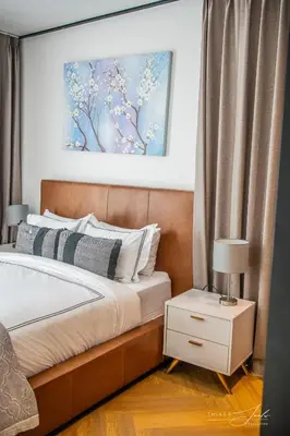 a bedroom with a bed and a picture on the wall at KML Nine Palms luxury 101 in Cape Town