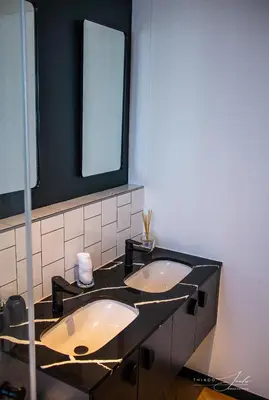 a bathroom with three sinks and a mirror at KML Nine Palms luxury 101 in Cape Town