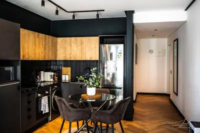 a kitchen with a table and chairs and a refrigerator at KML Nine Palms luxury 101 in Cape Town