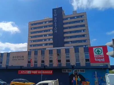 a large hotel building with cars parked in front of it at NEW BOSTON in Bellville