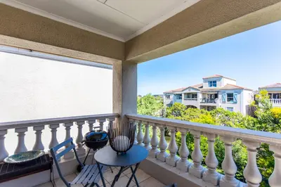 a balcony with a table and chairs and a large window at Dorphene 304 by CTHA in Cape Town