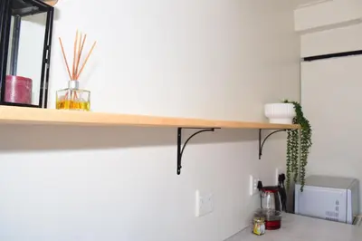 a kitchen counter with a wooden shelf on the wall at House on Pringle in Cape Town