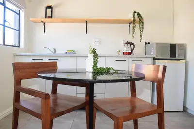 a kitchen with a table and two chairs and a counter at House on Pringle in Cape Town