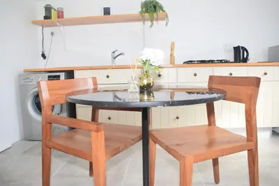 a kitchen table with two chairs and a vase with flowers at House on Pringle in Cape Town
