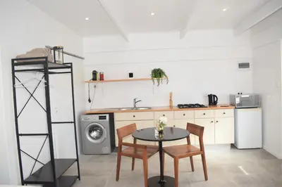 a kitchen with a table and chairs and a washing machine at House on Pringle in Cape Town