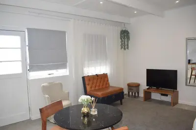a living room with a table and a television at House on Pringle in Cape Town