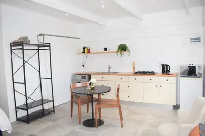 a kitchen with a table and chairs in a room at House on Pringle in Cape Town