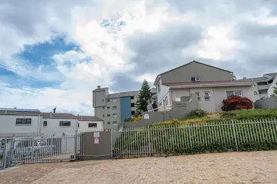 a fence in front of a house with buildings at Island view on Clam in Cape Town