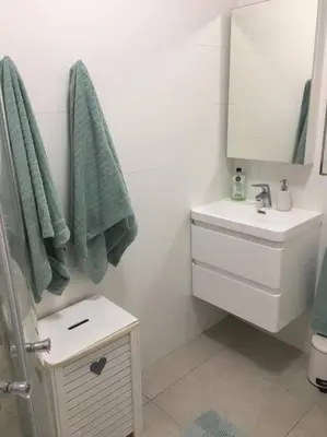 a white bathroom with a sink and a mirror at Lovely studio apartment in Pinelands, Cape Town in Cape Town